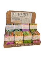 Display of Bentley Seed Co. medicinal herb seed packets in a wooden holder on a white background