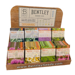 Display of Bentley Seed Co. medicinal herb seed packets in a wooden holder on a white background