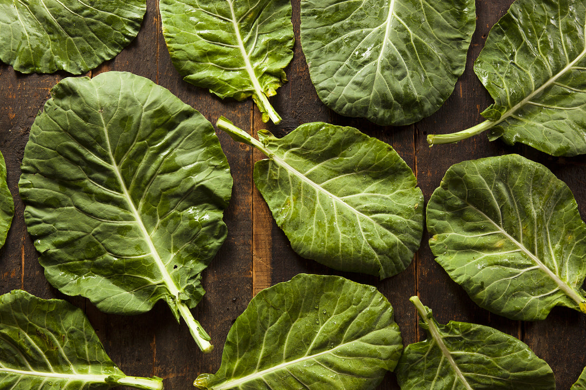 An array of collard greens on a rustic wooden table.