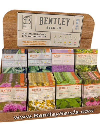 Display of Bentley Seed Co. medicinal herb seed packets in a wooden holder on a white background