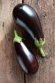 Two eggplants on rustic wooden table.