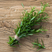 Bundle of heirloom Rosemary on a rustic wooden table.