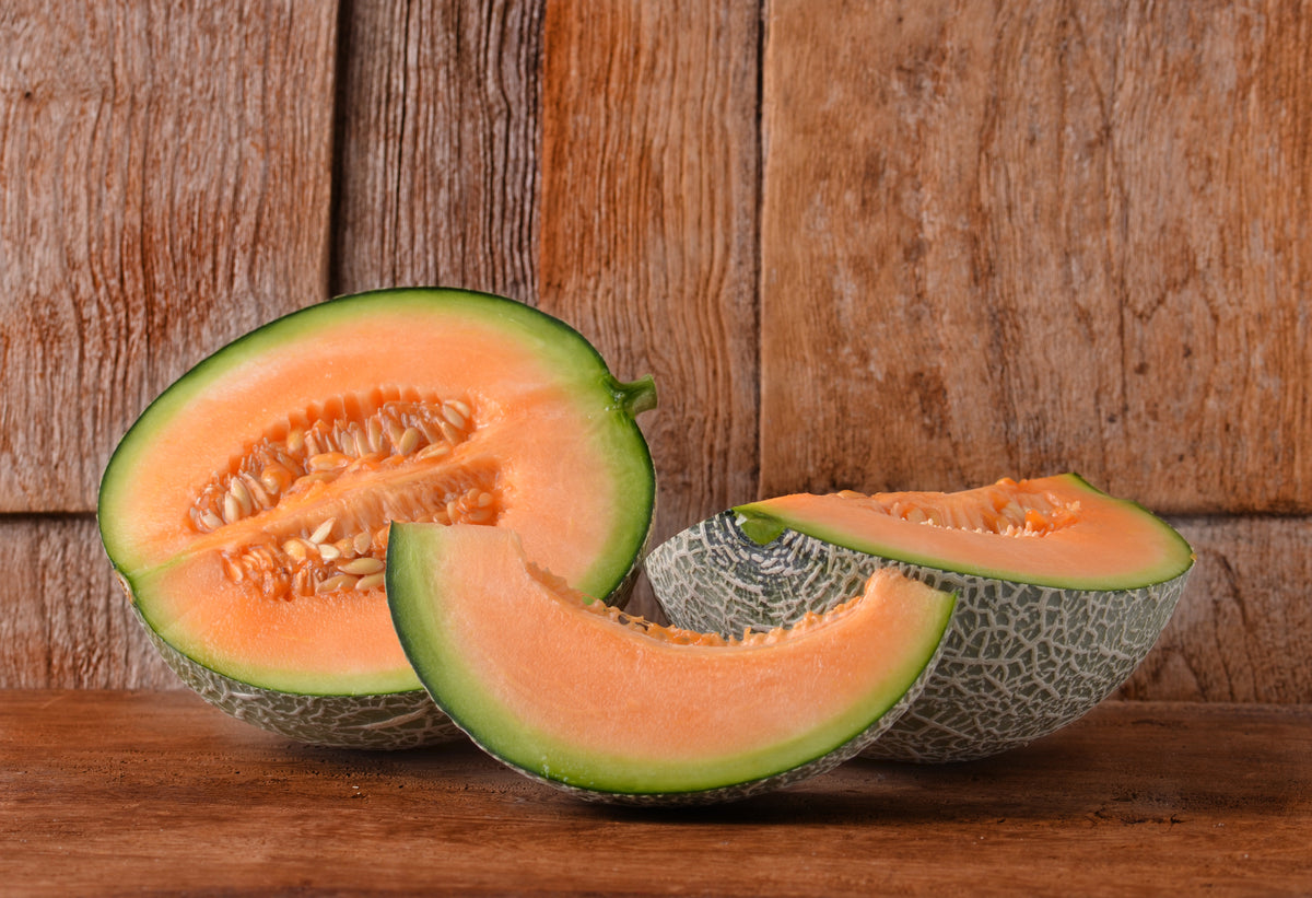 Sliced Cantaloupe on a rustic wooden background.
